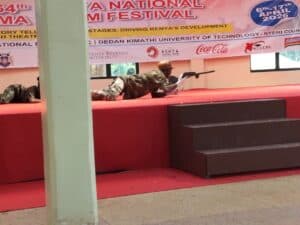 Shamberere National Polytechnic students perform a modern dance depicting the struggles of herders searching for pasture, where a herder is attacked by a monstrous threat but is rescued by officers who capture the creature. The performance took place at Nyeri National Polytechnic during the 64th Kenya National Drama and Film Festival.