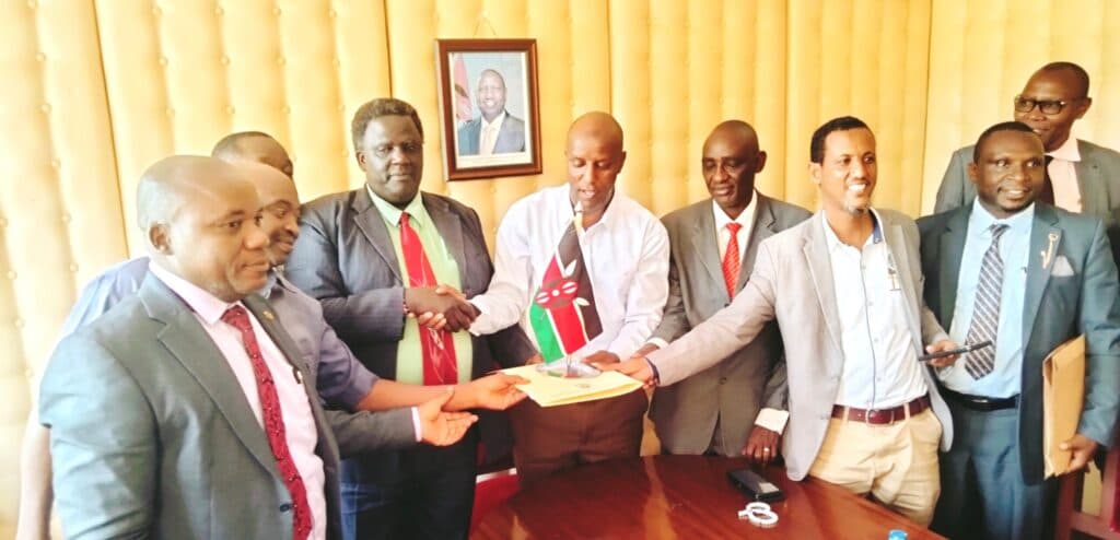 Makueni KNUT Branch Executive Secretary Benson Ndambuki (second left) with outgoing TSC Director Abubakar Hassan and other education stakeholders during the handover ceremony.