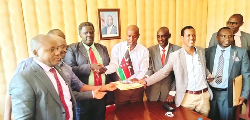 Makueni KNUT Branch Executive Secretary Benson Ndambuki (second left) with outgoing TSC Director Abubakar Hassan and other education stakeholders during the handover ceremony.