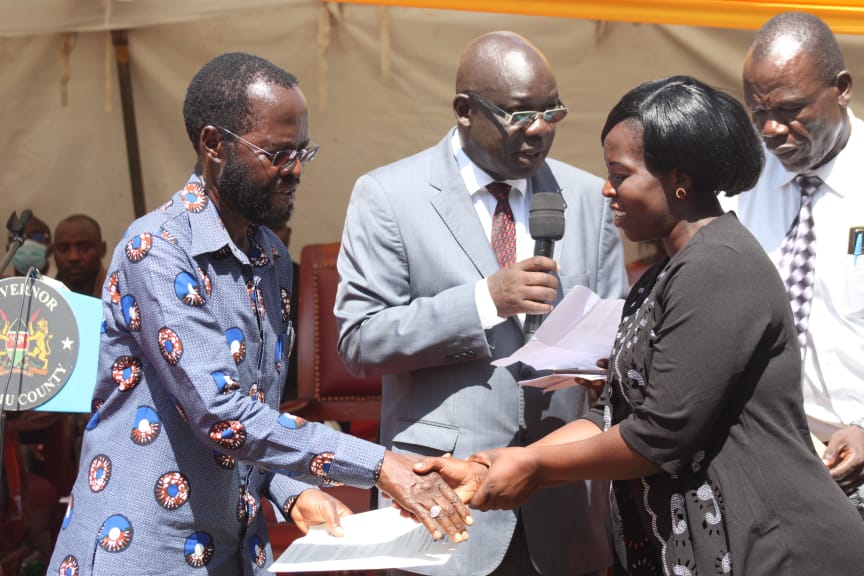Kisumu County Governor Prof. Anyang Nyongo flanked by his CEC for Education John Awiti presents appointment letters to ECDE teachers after being confirmed on permanent terms. Photo Fredrick Odiero