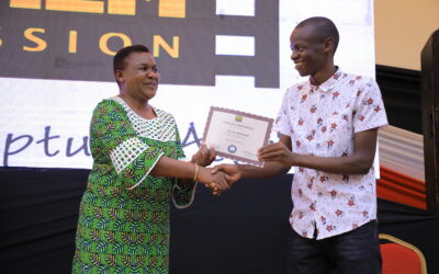 Kisii MP Doris Aburi awards a youth a certificate after he graduated in film production.