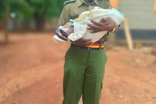 Photo of police nursing child as mother sits KCSE goes viral