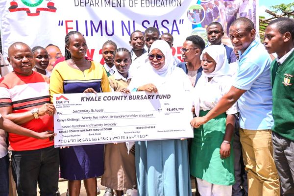 Governor Fatuma Achani issues a bursary dummy cheque to parents and students at Kinango in Kwale County on Friday January 3 2025