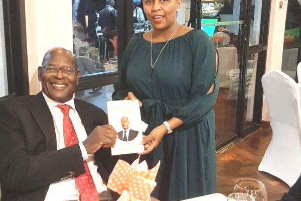 Mr. Kinisu presenting a signed copy of the book to Prof. CPA Elizabeth Muvui chairman of ICPAK at the Muthaiga Golf Club