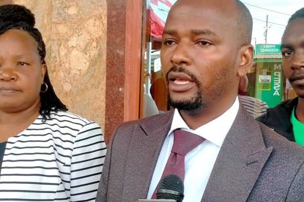 Equity Bank Tala Branch Manager Stephen Mutua addresses Elimu Scholarship beneficiaries during a flag off ceremony in Tala