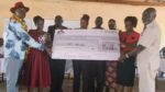Teso North MP Oku Kaunya and other officials displaying dummy cheque