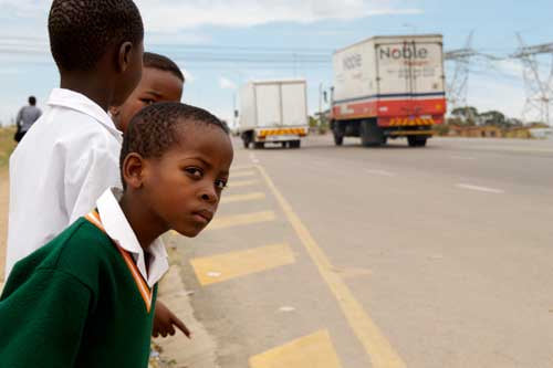Learners waiting to cross the road. The New NTSA traffic rules on instant fine will boost their safety and minimize accidents.
