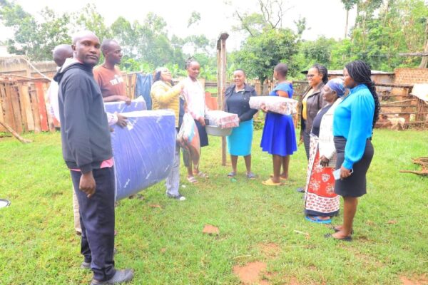 A rescued schoolgirl with her mother centre and staff members from the Kisii County Woman Representatives Office at the gate of Nduru Girls School. Photo Enock Okongo