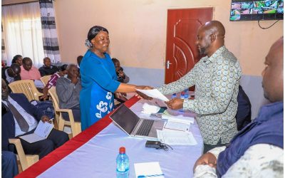 Uriri MP Mark Nyamira hands over bursary cheque to one of beneficiaries. Photo: Enock Okong'o.