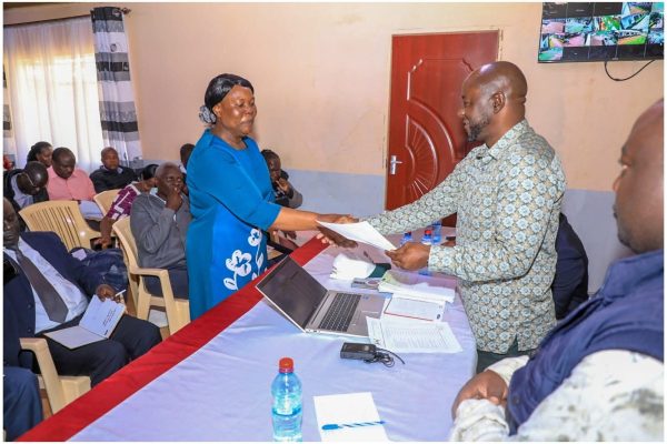 Uriri MP Mark Nyamira hands over bursary cheque to one of beneficiaries. Photo: Enock Okong'o.