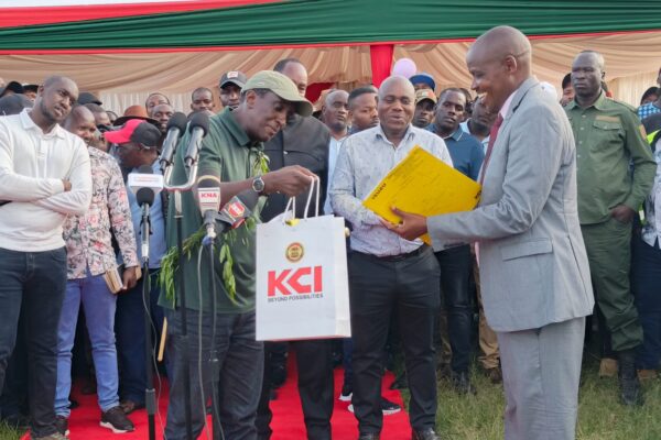Narok Governor Patrick ole Ntutu (left) hands over bus documents to Rongena Senior School Principal Paul Soi (right) during the official commissioning of the Sh10.5 million school bus funded by the Narok county government.