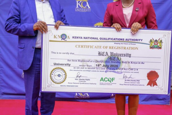 KCA Vice Chancellor Prof. Isaiah Wakindiki (l) and KNQA Director-General Dr. Alice Kande pose with a dummy certificate after the University was registered as QAB