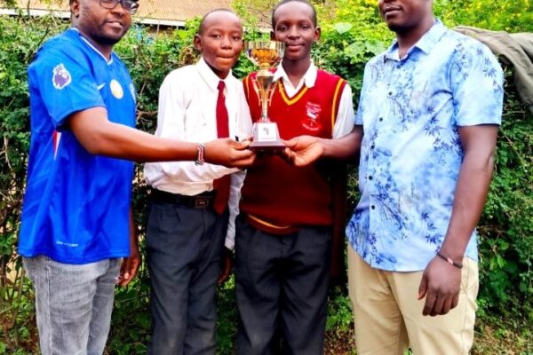 Carlos Mumo and Charles Mwendwa of Malivani AIC display their trophy with patrons James Wambua and Solomon Musyoki after KSEF Eastern regional competitions at Matuu Memorial Girls High School.
