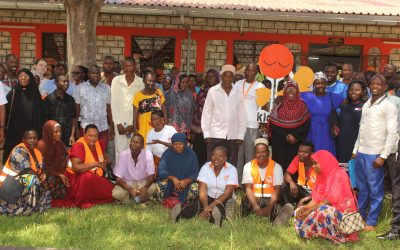 A section of the community members and Kids Care officials led by its director George Baya takes a group photo at Lunga-Lunga sub-county in Kwale County