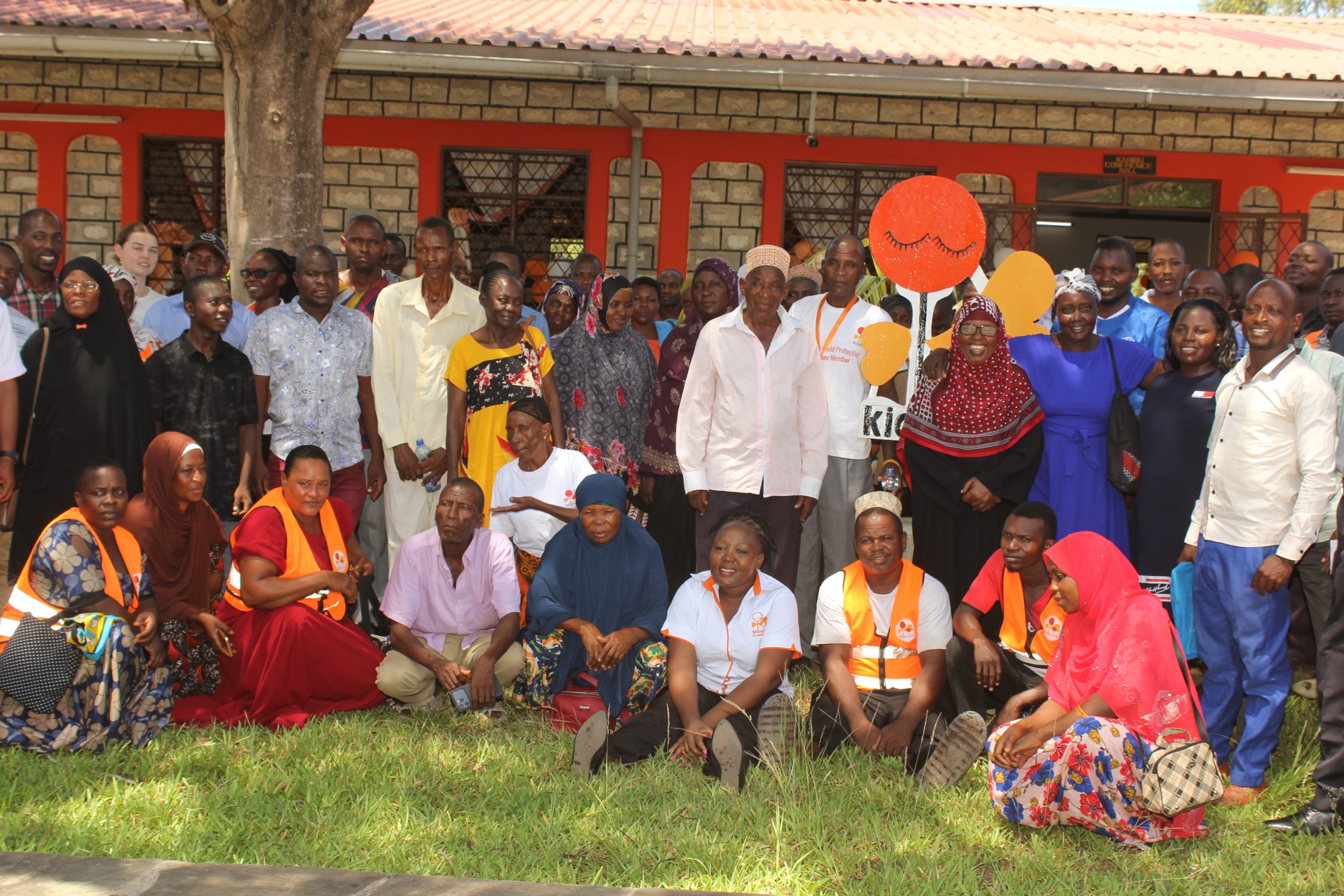 A section of the community members and Kids Care officials led by its director George Baya takes a group photo at Lunga-Lunga sub-county in Kwale County