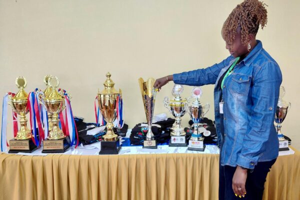 The lead patron and county coordinator, Fridah Mutuku showcases trophies won by Makueni Boys