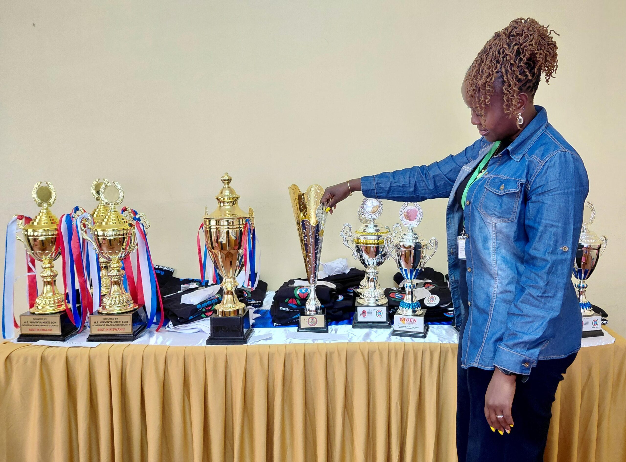 The lead patron and county coordinator, Fridah Mutuku showcases trophies won by Makueni Boys