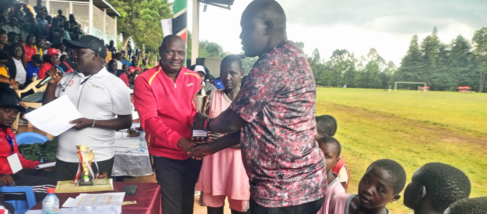 Senetwo Headteacher, Jonathan Lokudia receiving Position 1 trophy in Basketball in Rift Valley Region.