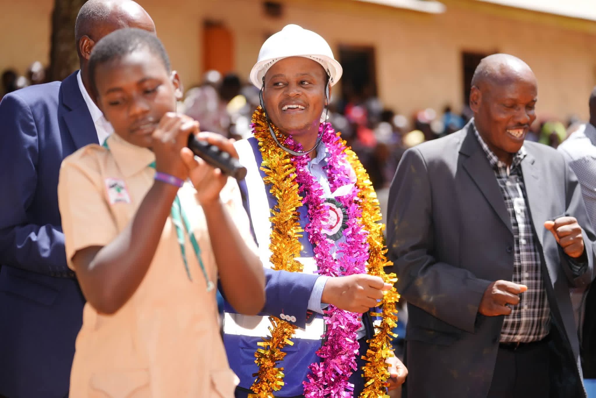 Bomachoge Borabu MP Obadiah Barongo in light moments with the stafff and Girl guide leader during the ground breaking ceremony for Kemoreko Comprehensive School. Photo/Enock Okong'o.