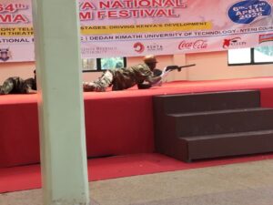 Shamberere National Polytechnic students perform a modern dance depicting the struggles of herders searching for pasture, where a herder is attacked by a monstrous threat but is rescued by officers who capture the creature. The performance took place at Nyeri National Polytechnic during the 64th Kenya National Drama and Film Festival.