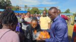 Malava MP aspirrant John Wanyama (l) distributing scones to learners