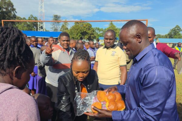 Malava MP aspirrant John Wanyama (l) distributing scones to learners