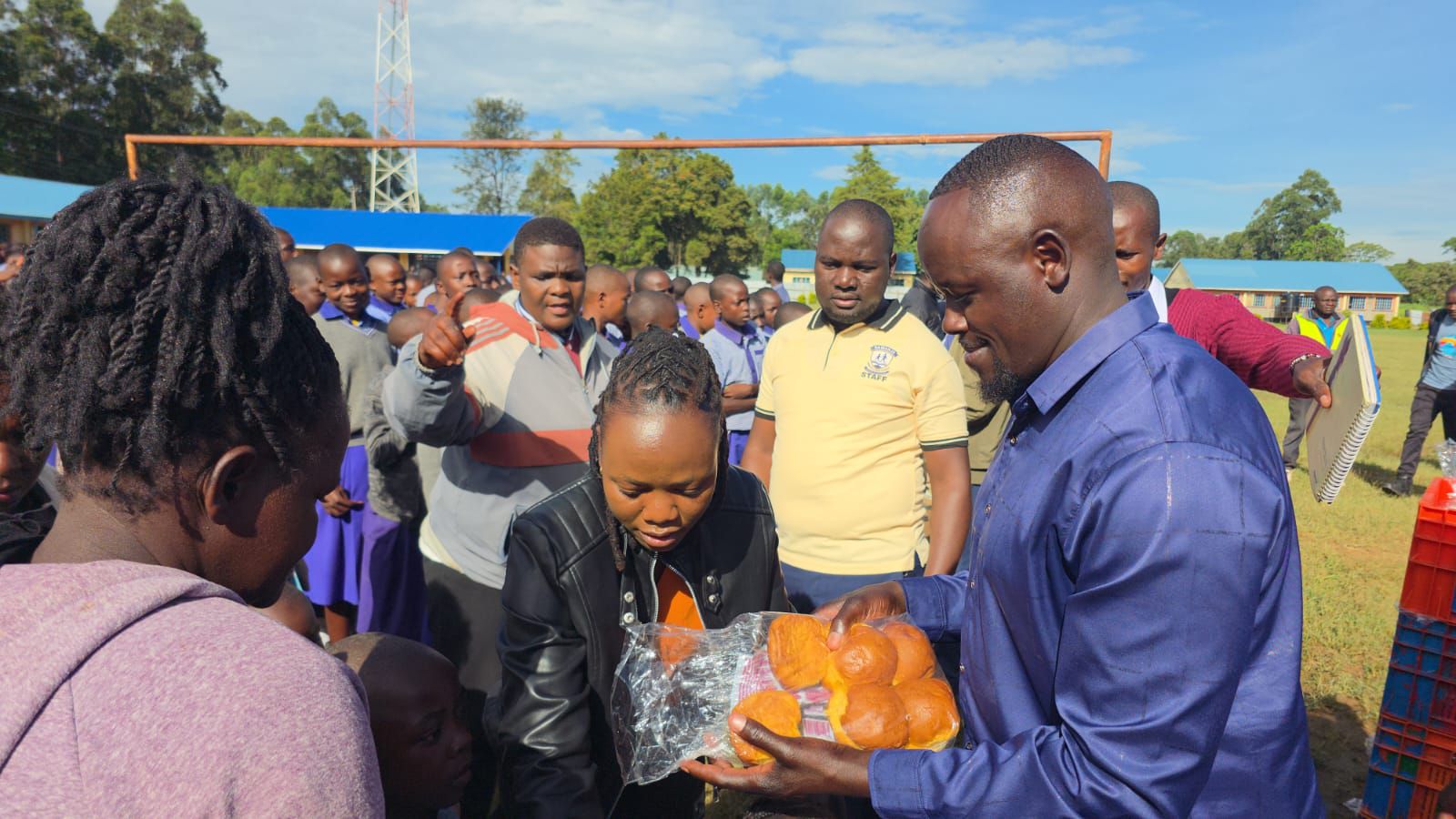 Malava MP aspirrant John Wanyama (l) distributing scones to learners