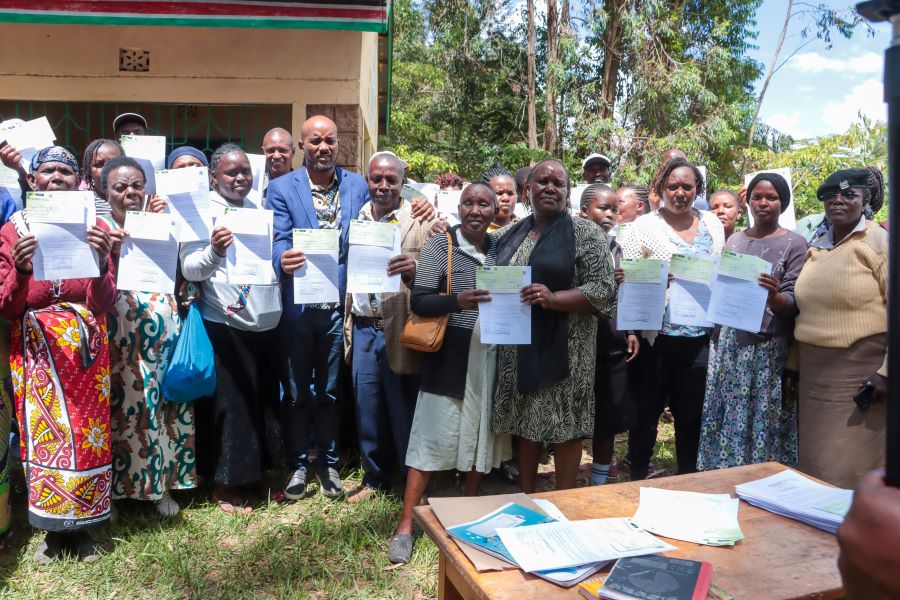 Machakos County Executive Catherine Mutanu (centre) and Mumbuni North Ward MCA Antony Kisoi (in blue suit) issue bursary cheques to parents of beneficiaries in Mumbuni on May 13, 2026.