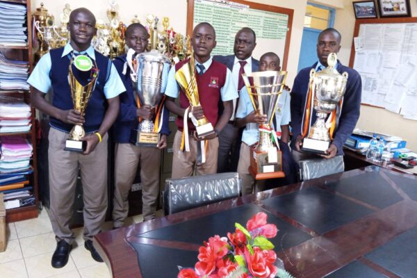 Friends Vihiga Boys Chief Principal Albert Masiolo receiving trophies won by the school during Western Region Chapa Dimba 2026 and Music Festival both at National and East African level.