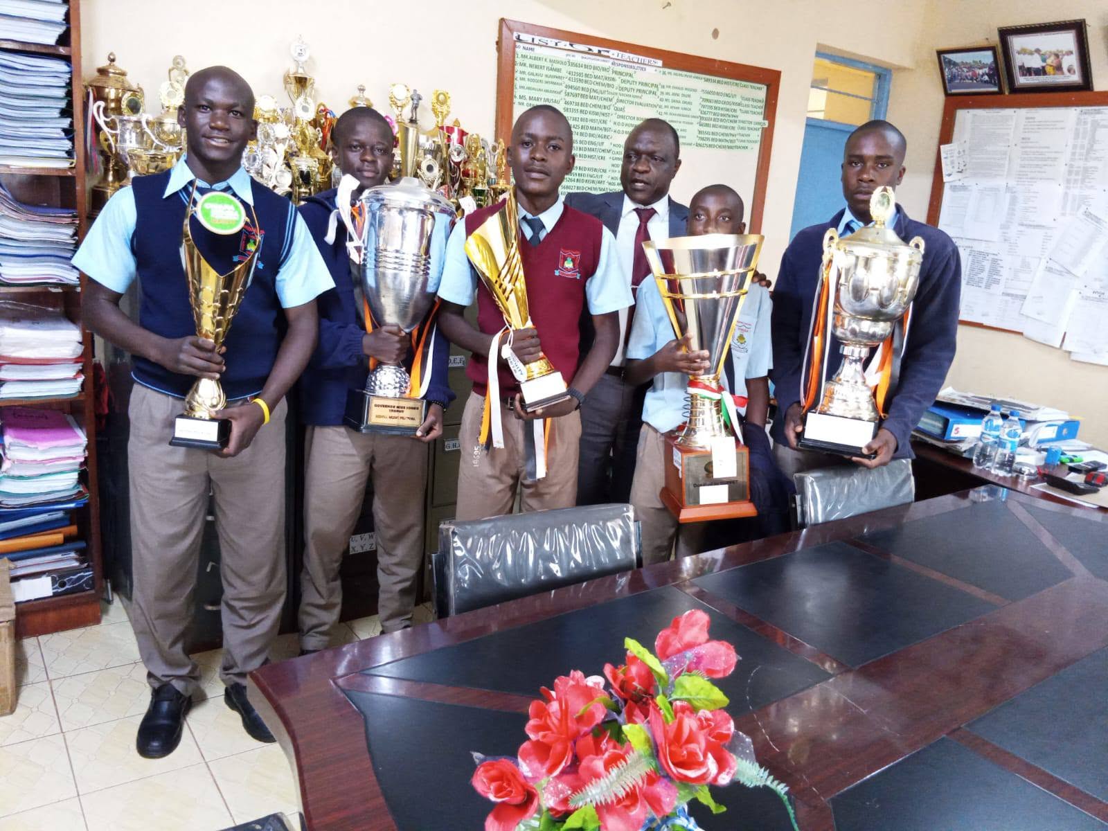 Friends Vihiga Boys Chief Principal Albert Masiolo receiving trophies won by the school during Western Region Chapa Dimba 2026 and Music Festival both at National and East African level.