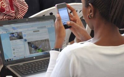 A woman using a smart phone and a laptop to browse-According to KNBS Nairobi is Kenya's most internet-connected county