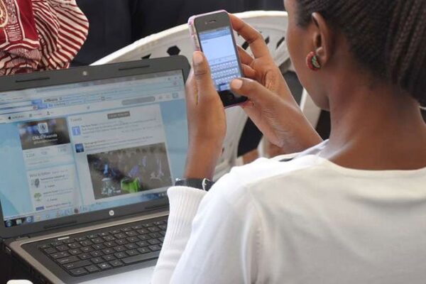 A woman using a smart phone and a laptop to browse-According to KNBS Nairobi is Kenya's most internet-connected county
