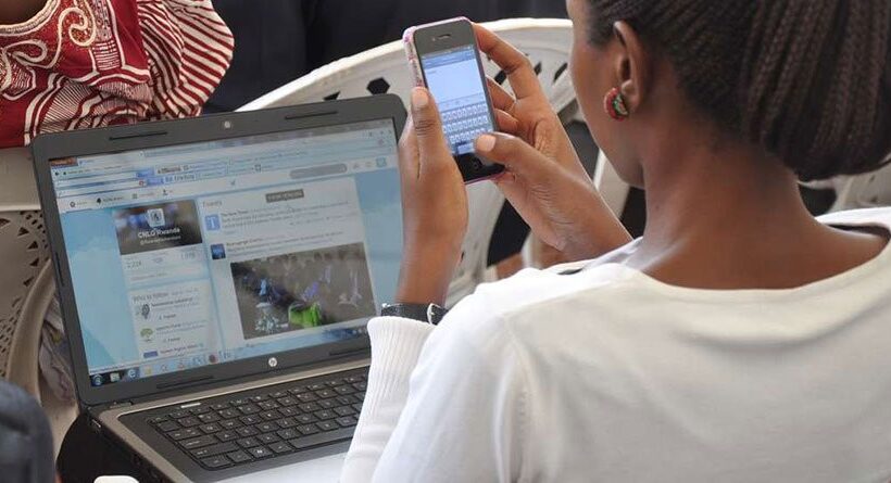 A woman using a smart phone and a laptop to browse-According to KNBS Nairobi is Kenya's most internet-connected county