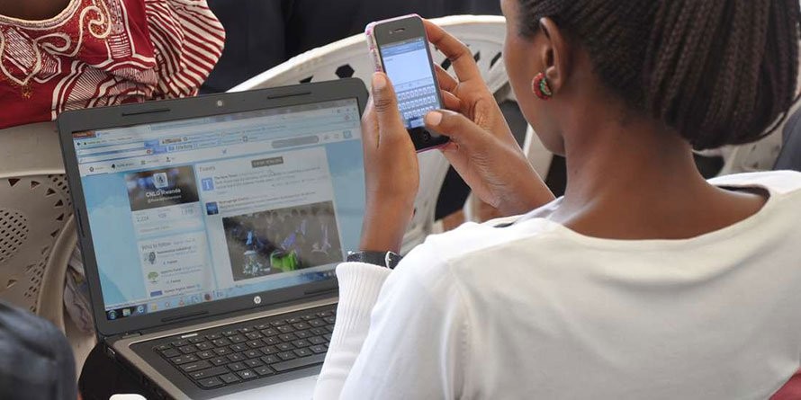 A woman using a smart phone and a laptop to browse-According to KNBS Nairobi is Kenya's most internet-connected county
