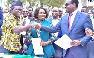 UASU Secretary General Constantine Wasonga (left) shakes hands with Education CS Julius Ogamba after signing the return-to-work deal