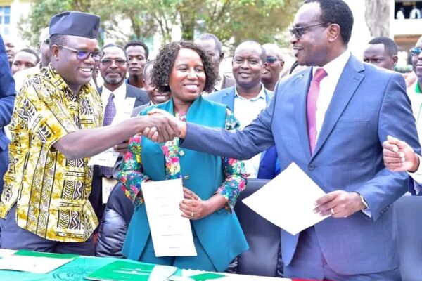 UASU Secretary General Constantine Wasonga (left) shakes hands with Education CS Julius Ogamba after signing the return-to-work deal