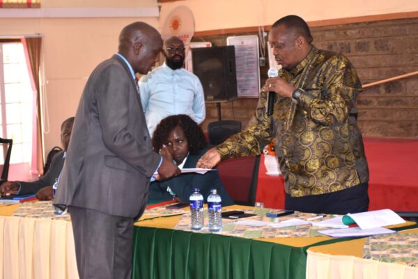 Gilbert Kiprono Sang (left) presents a petition to Baringo North MP Joseph Makilap (right), a member of the National Assembly Education Committee, during a public participation forum on the proposed Education Reform Bills in Narok