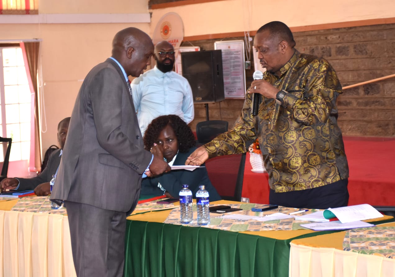 Gilbert Kiprono Sang (left) presents a petition to Baringo North MP Joseph Makilap (right), a member of the National Assembly Education Committee, during a public participation forum on the proposed Education Reform Bills in Narok
