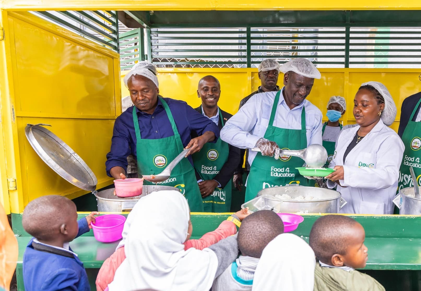 President William Ruto and Deputy President Kithuer Kindiki serve lunch to children during the opening of Dishi na County Central Kitchen on March 10, 2025