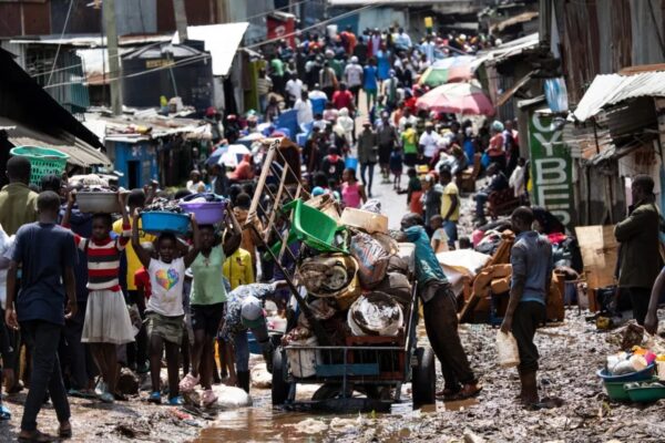 Kawangware Residents wade through a muddy road after a heavy downpour-Photo|AFP