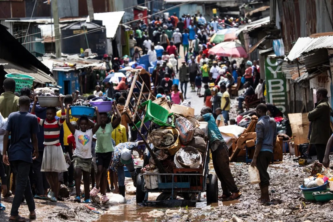 Kawangware Residents wade through a muddy road after a heavy downpour-Photo|AFP